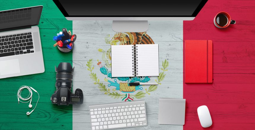 Mexico flag background with headphone,camera, notebook and mouse on national office desk table.Top view with copy space.Flat Lay.